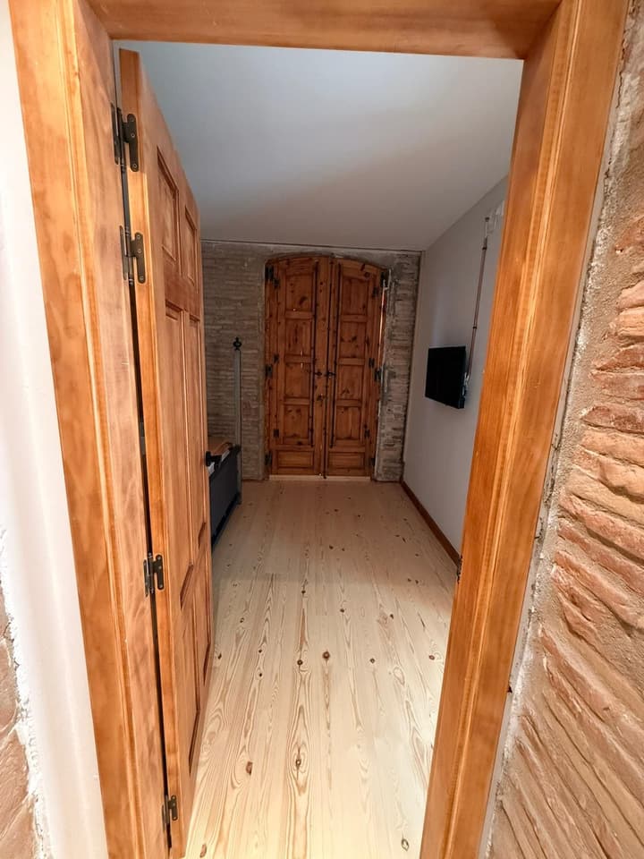 Estancia reformada con puertas antiguas de madera restauradas y muro de piedra vista
