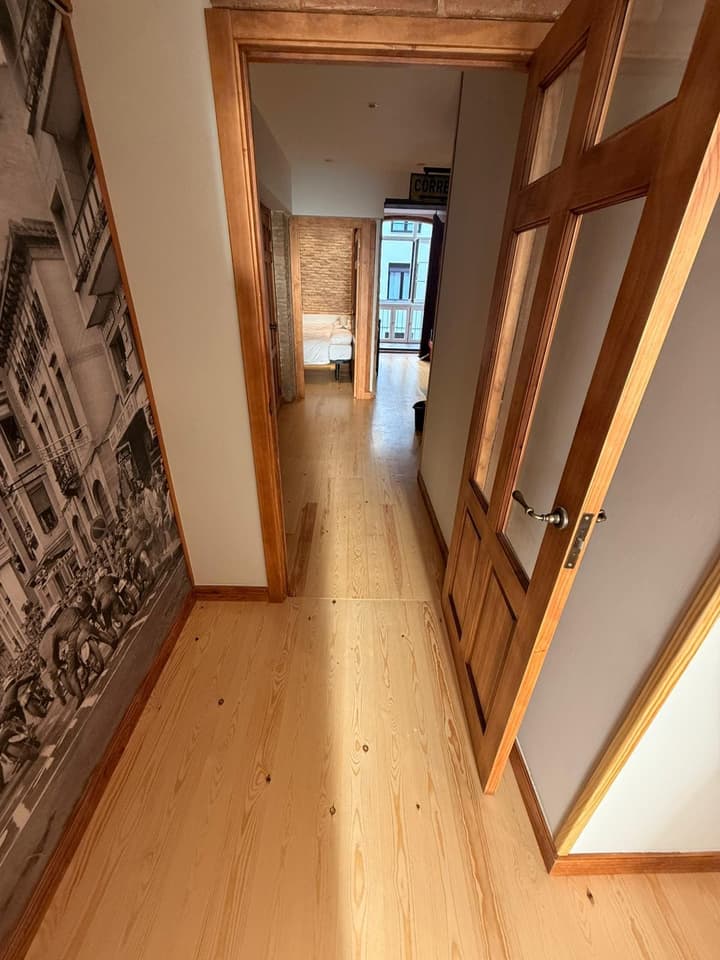 Pasillo reformado con suelo de pino macizo, puertas de madera restauradas y mural fotográfico