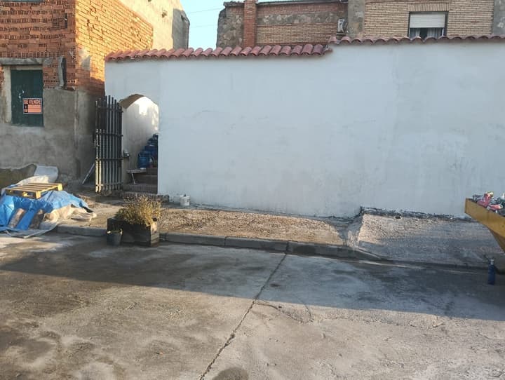 Fachada de edificio rehabilitada por JIMA, pintada en blanco y rematada con teja
